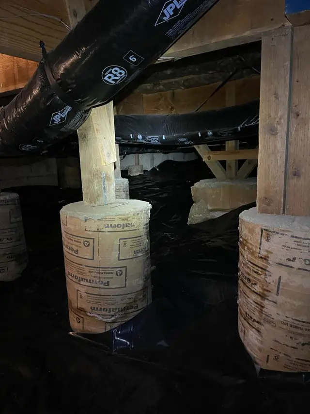 Piers wrapped and barrier sealed in a drained crawl space