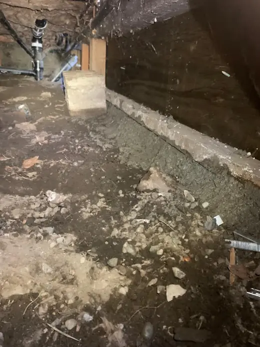 Crawl space soil and debris before cleanout