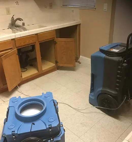 Air scrubber and dehumidifier drying a kitchen after water damage