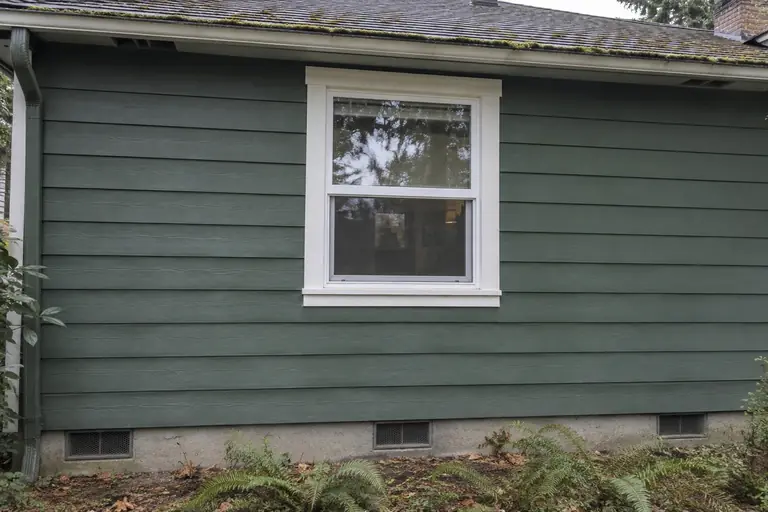 Exterior drill-and-fill on a Craftsman rambler, after: The wall is restored to a clean, sealed condition with no visible gaps or holes; the insulation job is complete and the repairs blend seamlessly with the original siding.
