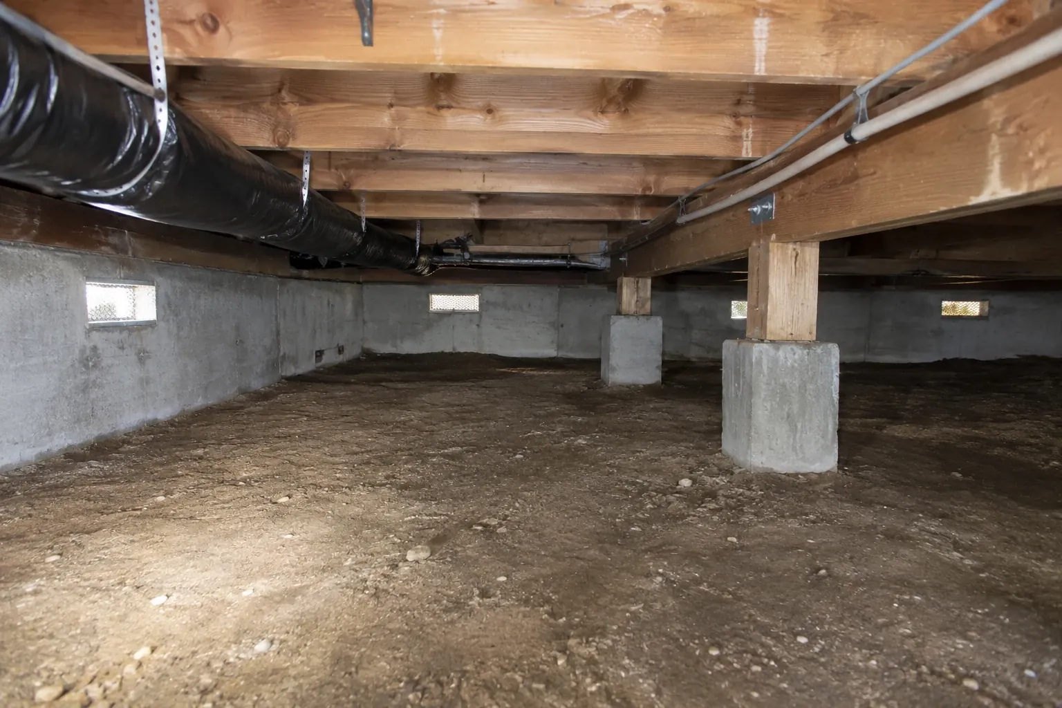 A cleaned crawl space with a bare dirt floor.