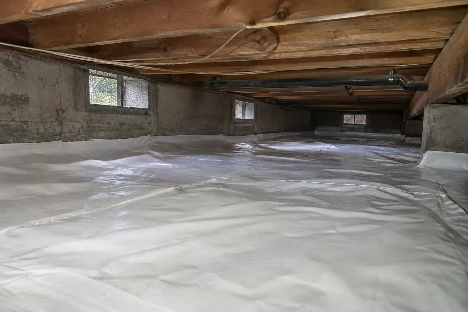 After: The crawl space is finished with a new white vapor barrier securely installed.