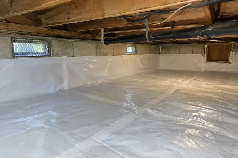 Crawl space cleaning with worn vapor barrier in Tacoma ranch, after: The crawl space floor is fully covered with a new, intact vapor barrier, leaving the area clean, dry, and well protected.