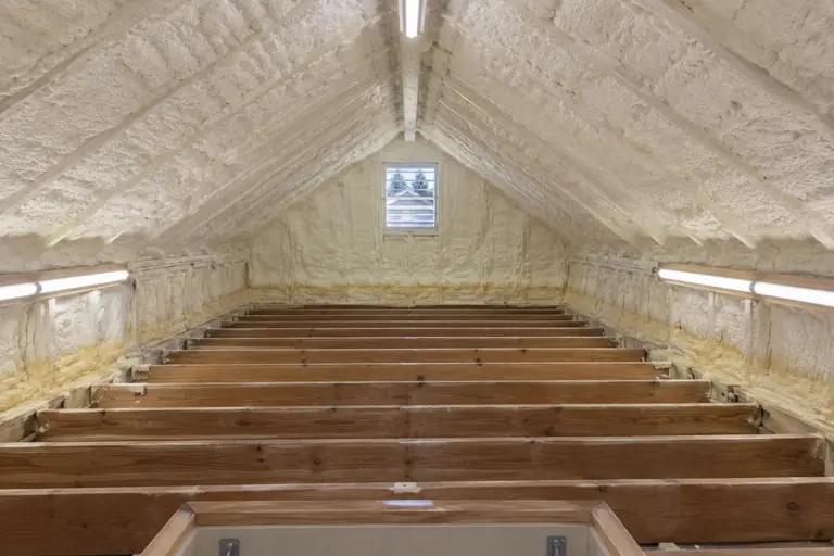 Spray foam insulation on an attic roof deck, after: The attic insulation replacement is complete.