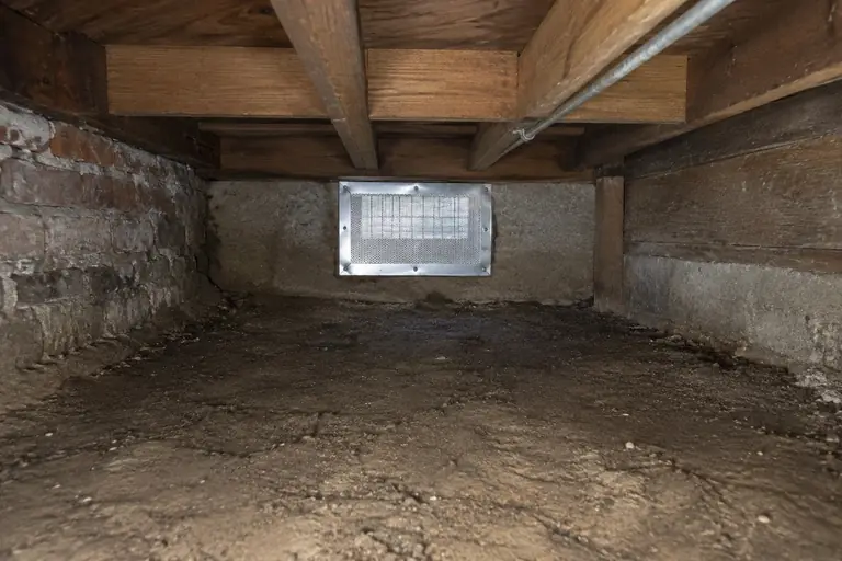 Crawl space rodent proofing in a Seattle Craftsman bungalow, after: The crawl space vent is fully rodent-proofed with steel mesh and metal patching, and the area is cleaned and sealed against further infestation.